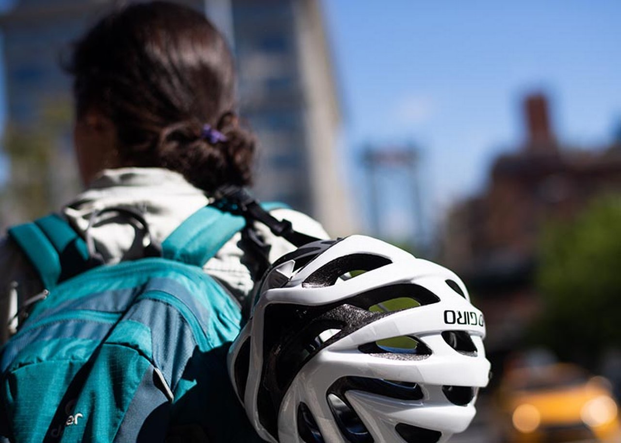 Woman with backpack and bicycle helmet, seen from behind