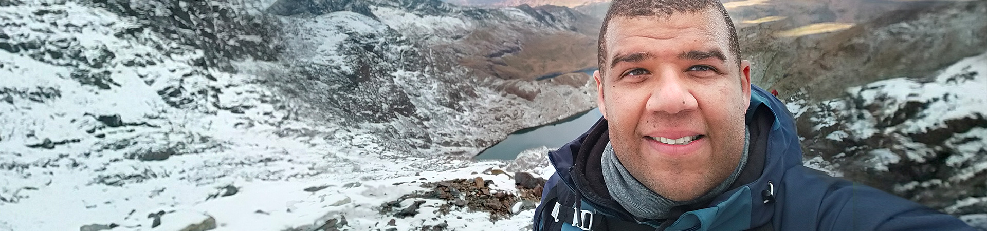 Tim George selfie with snowy mountains behind him