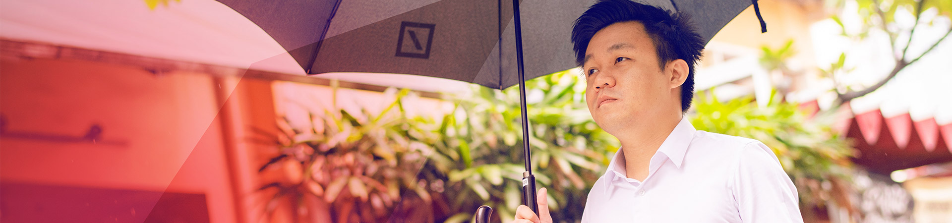Melvyn is standing outside under an umbrella