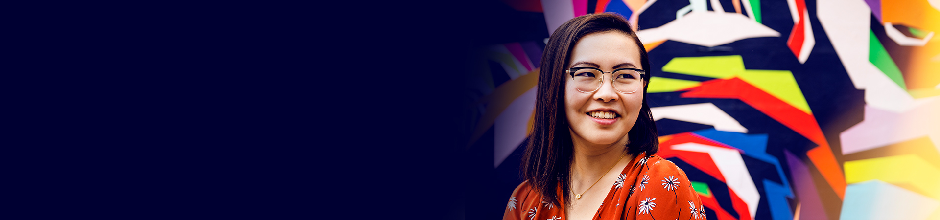 Tina in front of a colorful wall drawing