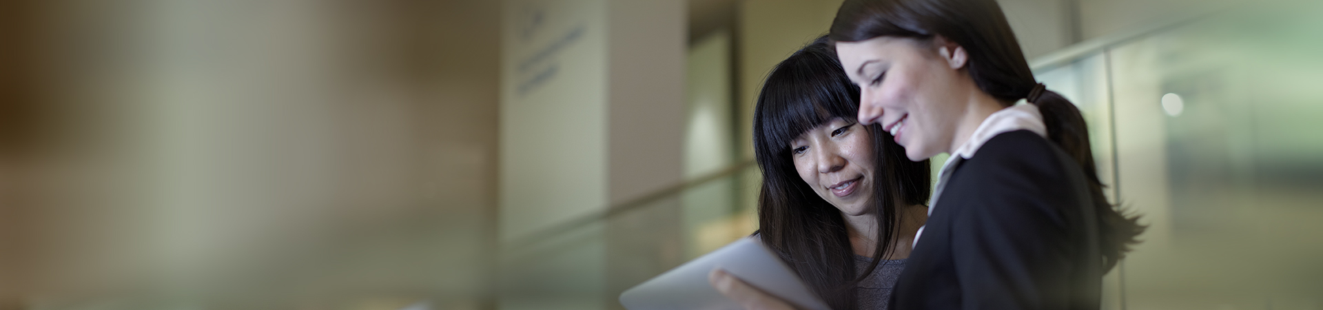 Two colleagues smiling using an iPad