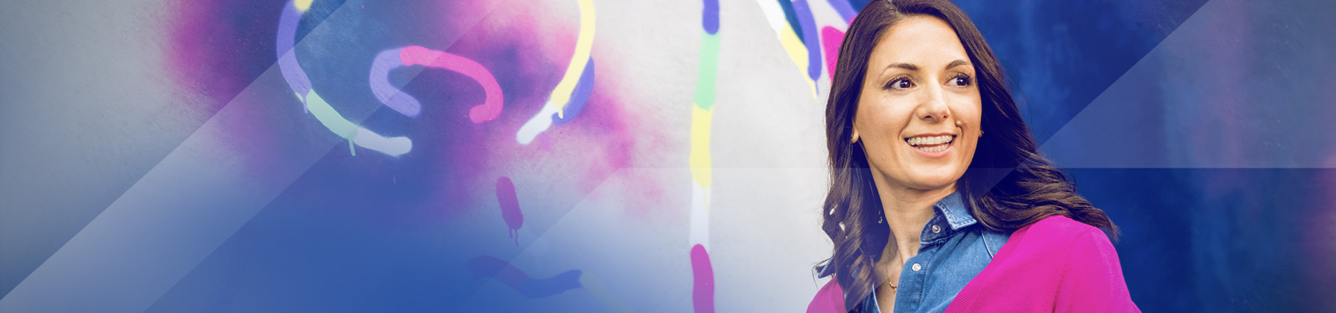 Gabriela smiling against a colourful graffiti backdrop